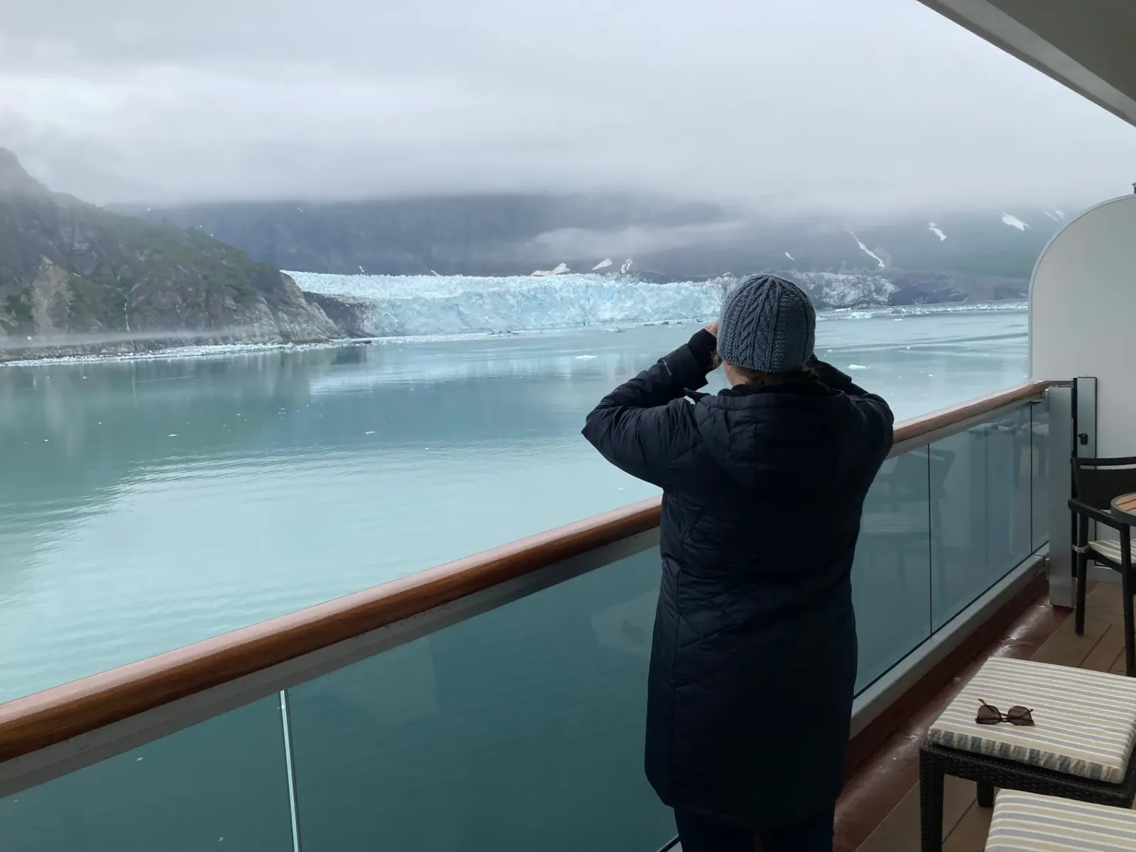 Guest on a private balcony watching a tidewater glacier drift past in Glacier Bay