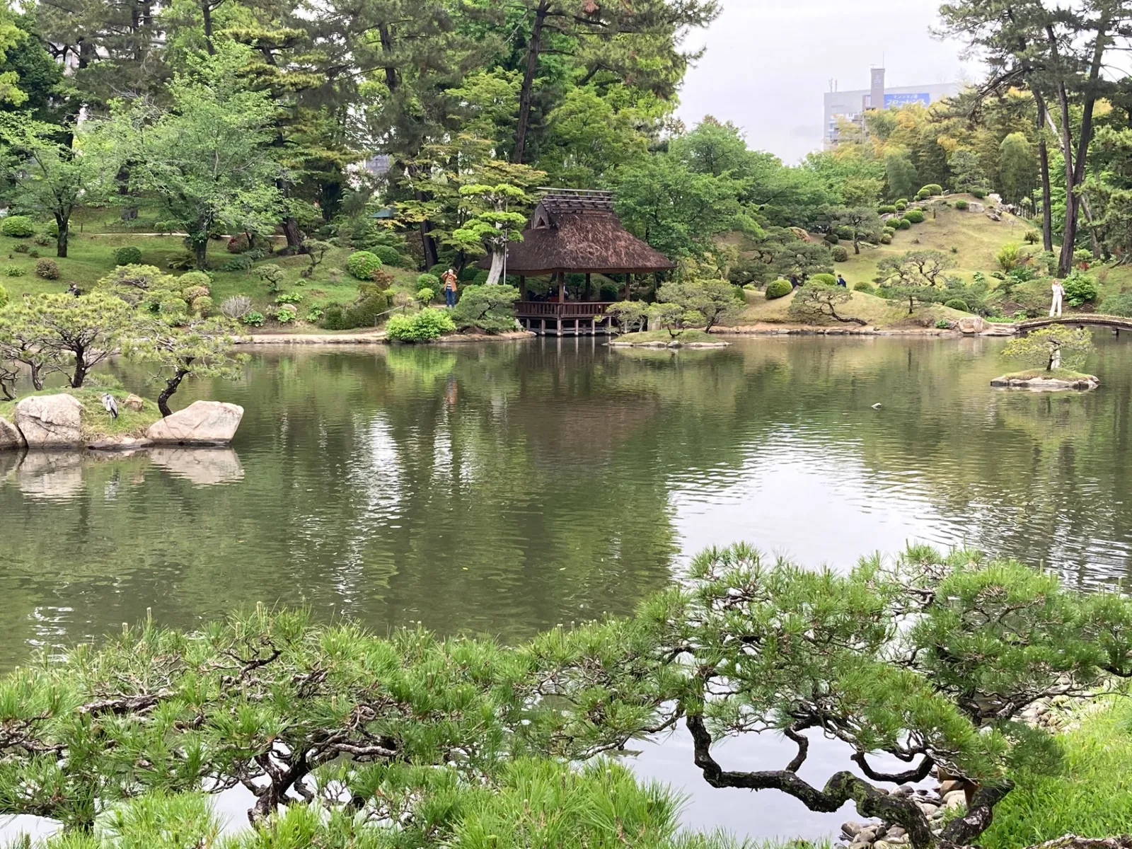 Thatched teahouse and pond at Shukkei-en garden in Hiroshima