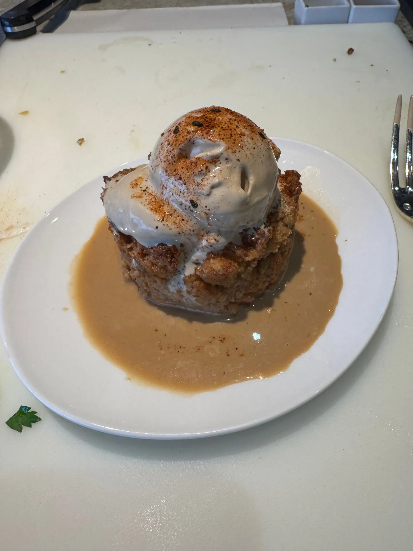 Warm bread pudding topped with ice cream and bourbon sauce from a Culinary Center class