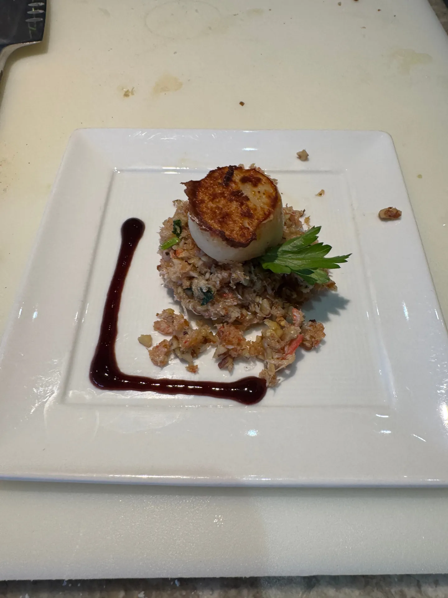 Seared scallop over crab plated in the Culinary Arts Kitchen on Regent Seven Seas