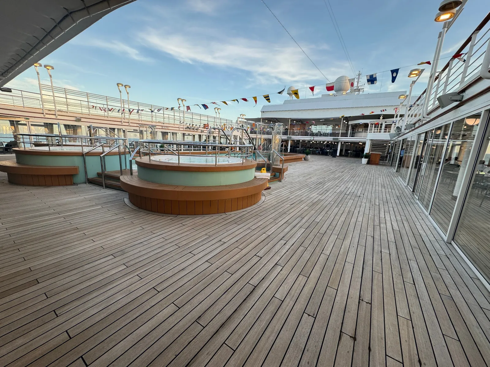 Silversea pool deck at golden hour with teak decking and hot tubs